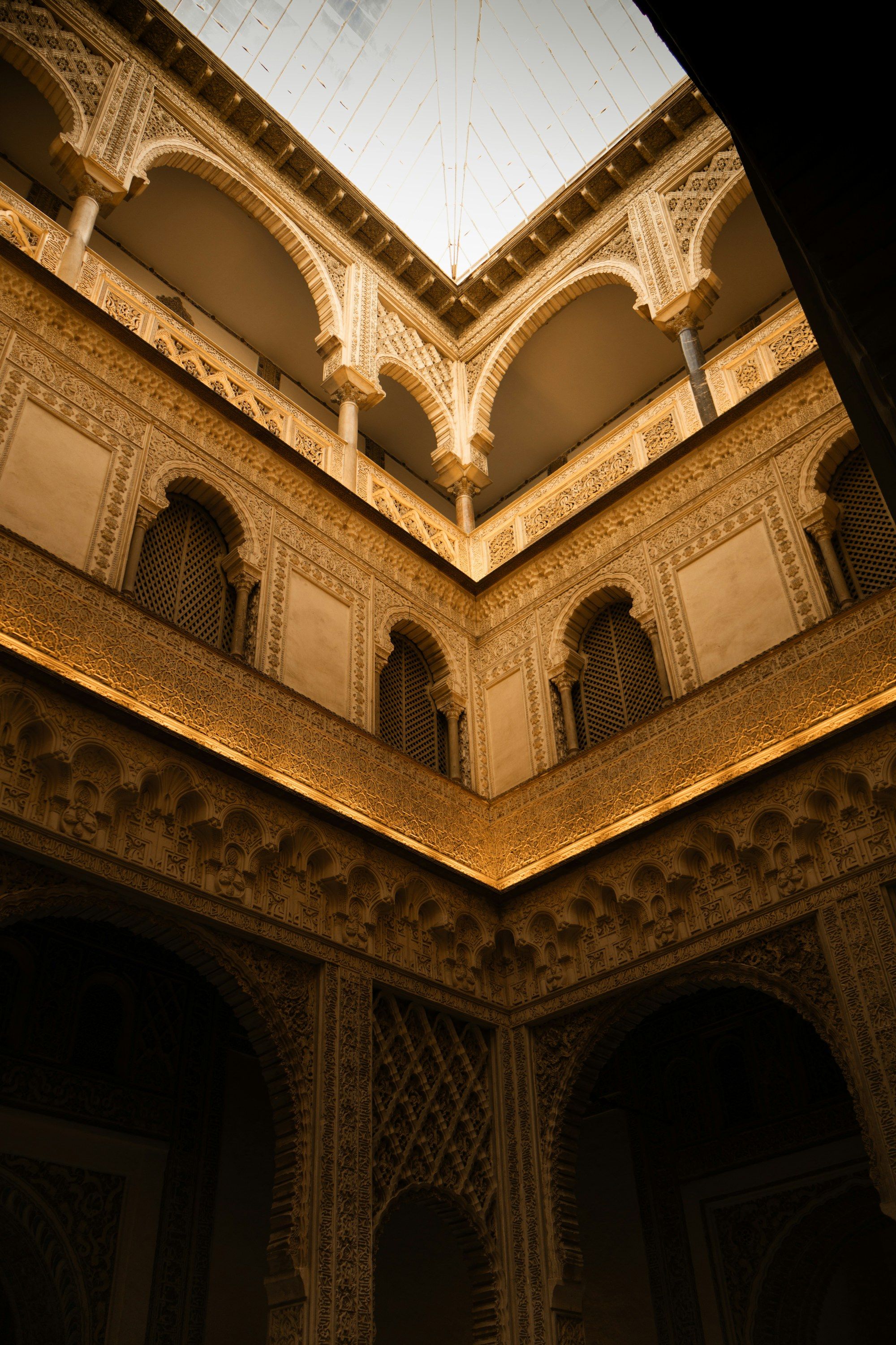 A carved courtyard with arched windows, lit warm at night