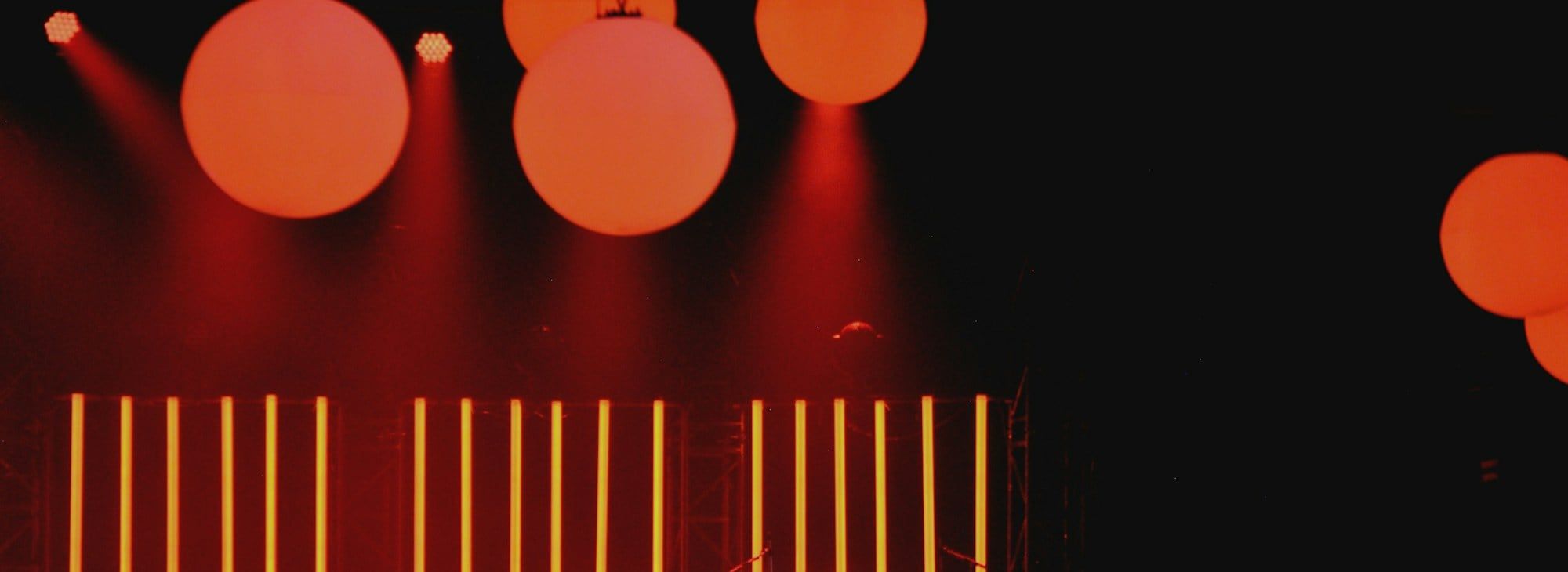 An empty stage lit with warm orange lights and hanging lanterns