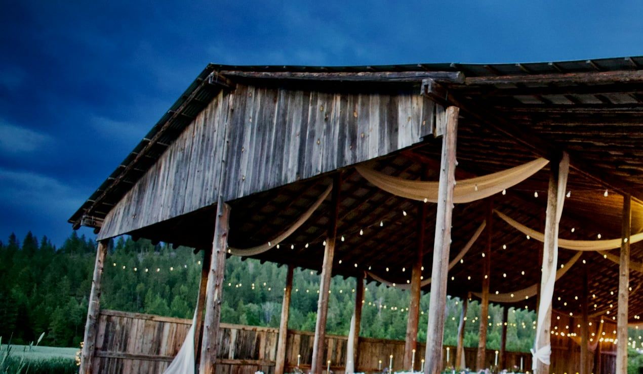 An open-sided venue strung with warm lights at dusk